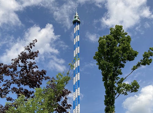 Aussichtsturm mit blauer und weißer Streifenmuster unter einem klaren Himmel.