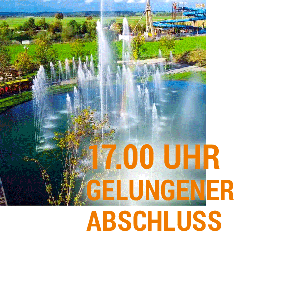Wasserspiele im Skyline Park Sprudelnde Wasserfontänen in einem Park mit einem Freizeitpark im Hintergrund.