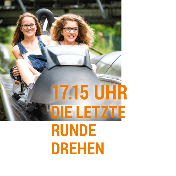 Zwei Mädchen auf einer Achterbahn Zwei Mädchen sitzen auf einer Achterbahn und lächeln in die Kamera.